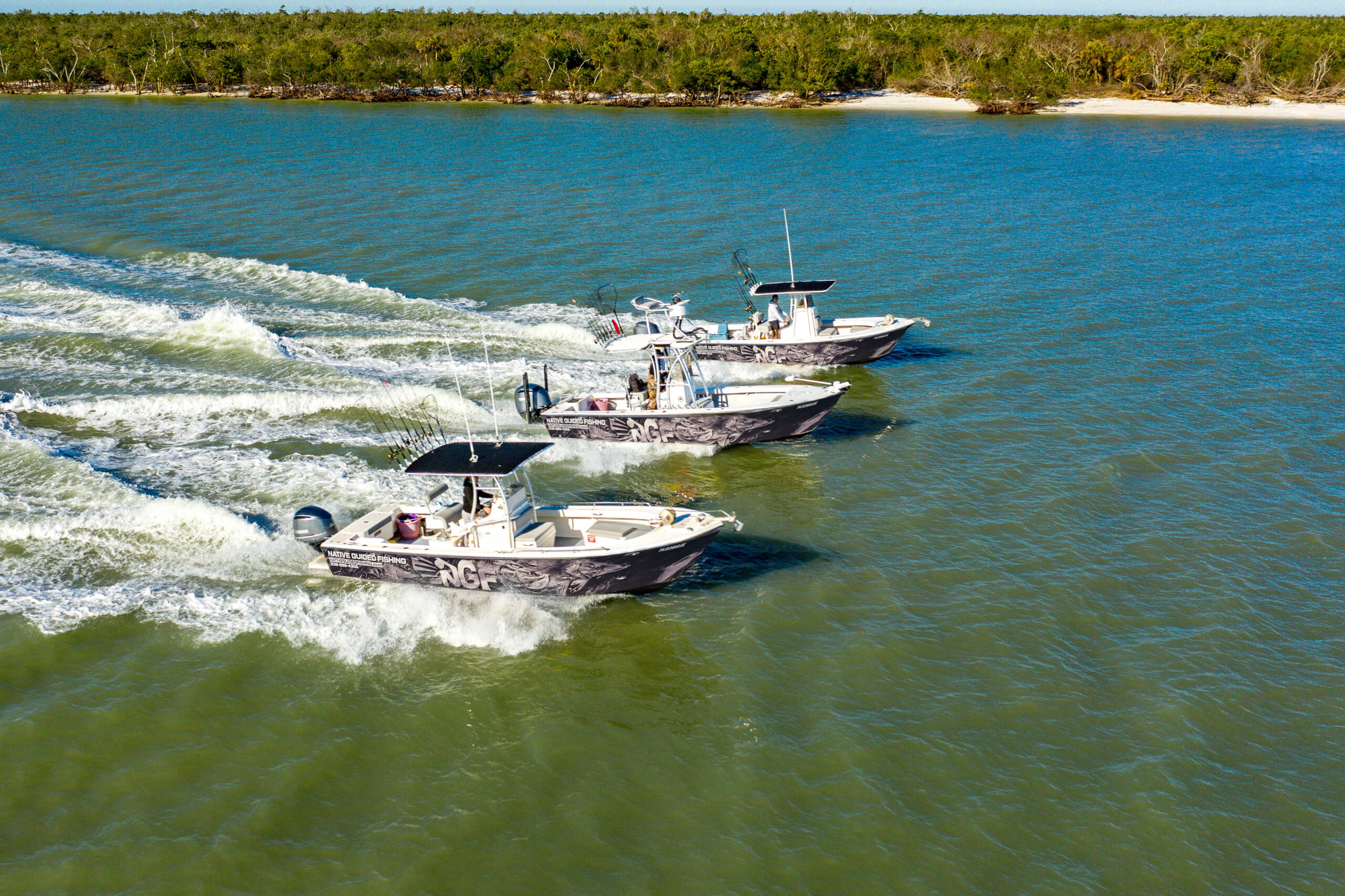 Three Native Guided Fishing charter boats running across sunlit Gulf waters